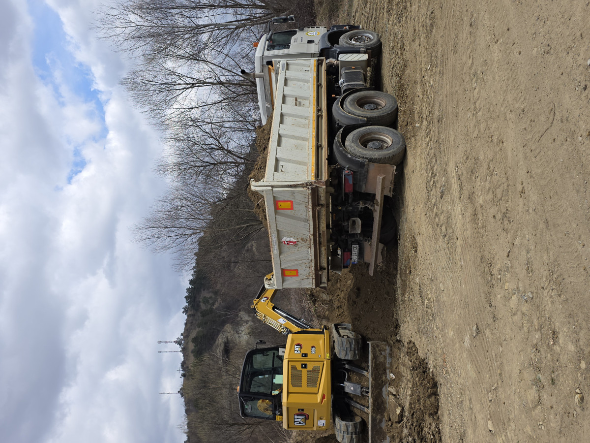 Basculantă 27t MAN cu basculare trilaterală și miniexcavator Caterpillar 305 pe șantier, Bacău