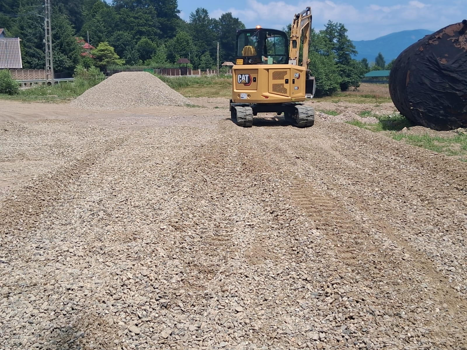 Miniexcavator Caterpillar 305 pe platformă pregătită cu piatră spartă